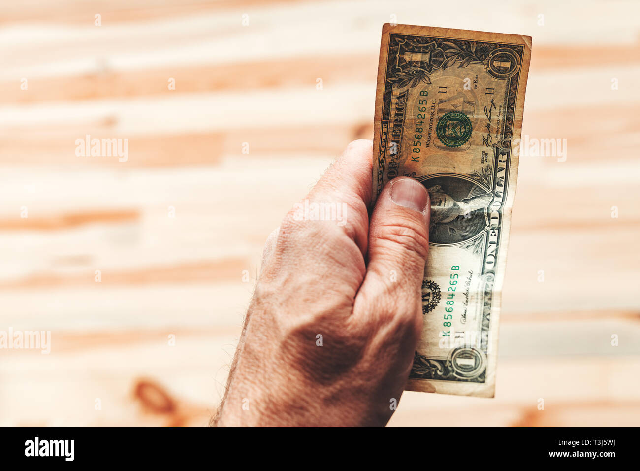 Uomo di pagare con un dollaro USA Bill, close up dei maschi di mano azienda americana valuta della carta Foto Stock