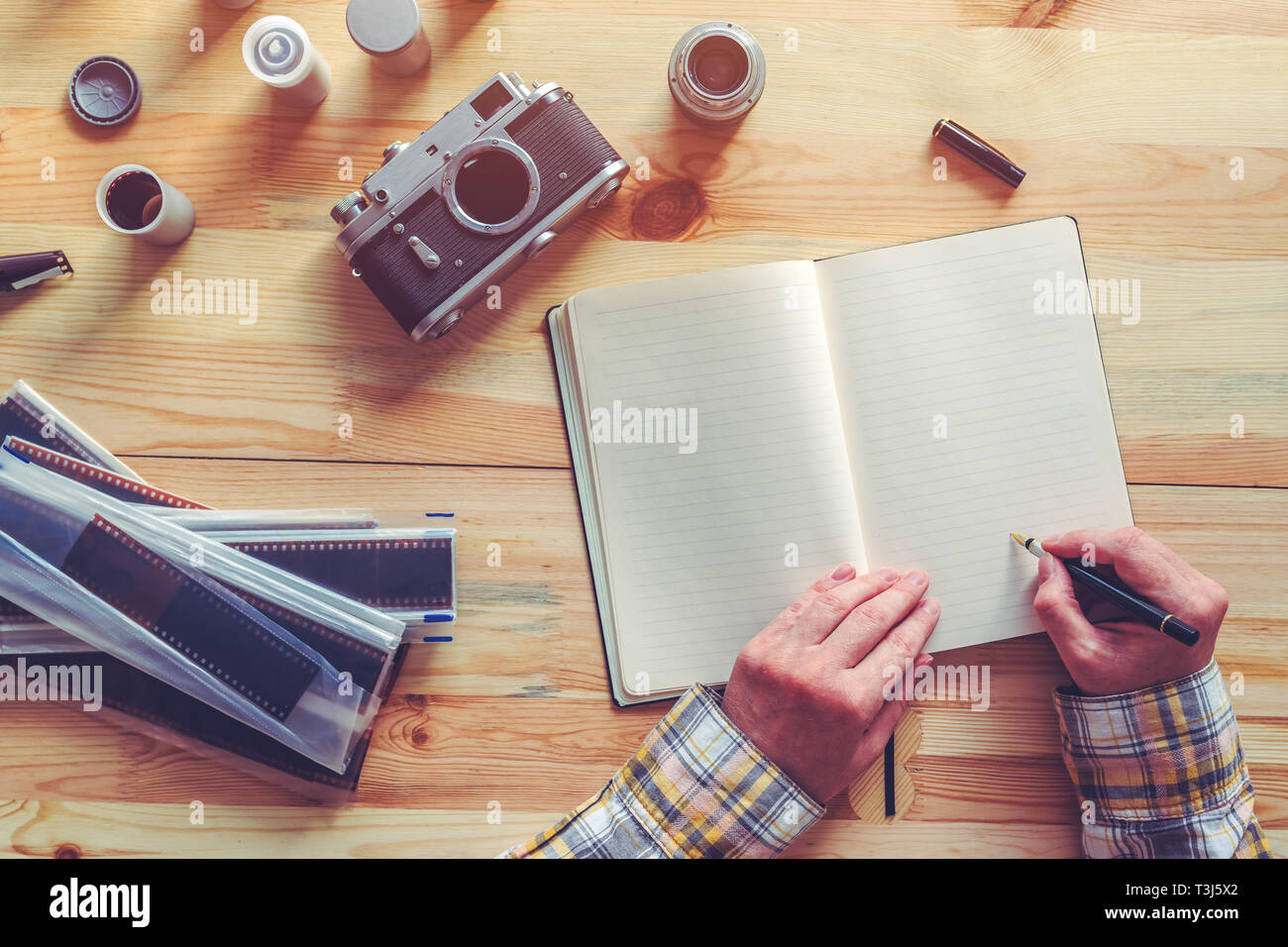 Fotografo la pianificazione di una fotografia, scrivere le note e la lista delle attività in note book, vista dall'alto Foto Stock