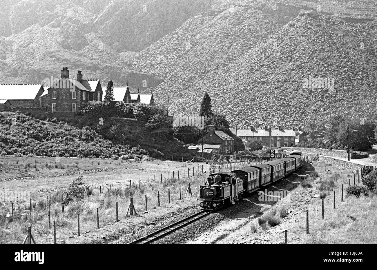 Locomotiva a vapore Merddin Emrys sul Ffestiniog Railway in esecuzione attraverso Blaenau Ffestiniog miniere di ardesia, Gwynedd, il Galles del Nord Foto Stock