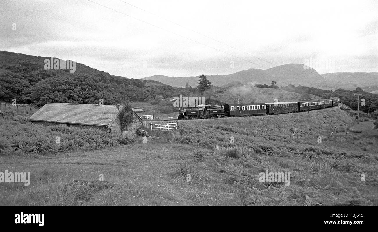 Locomotiva a vapore Merddin Emrys sul Ffestiniog Railway in esecuzione attraverso Blaenau Ffestiniog miniere di ardesia, Gwynedd, il Galles del Nord Foto Stock