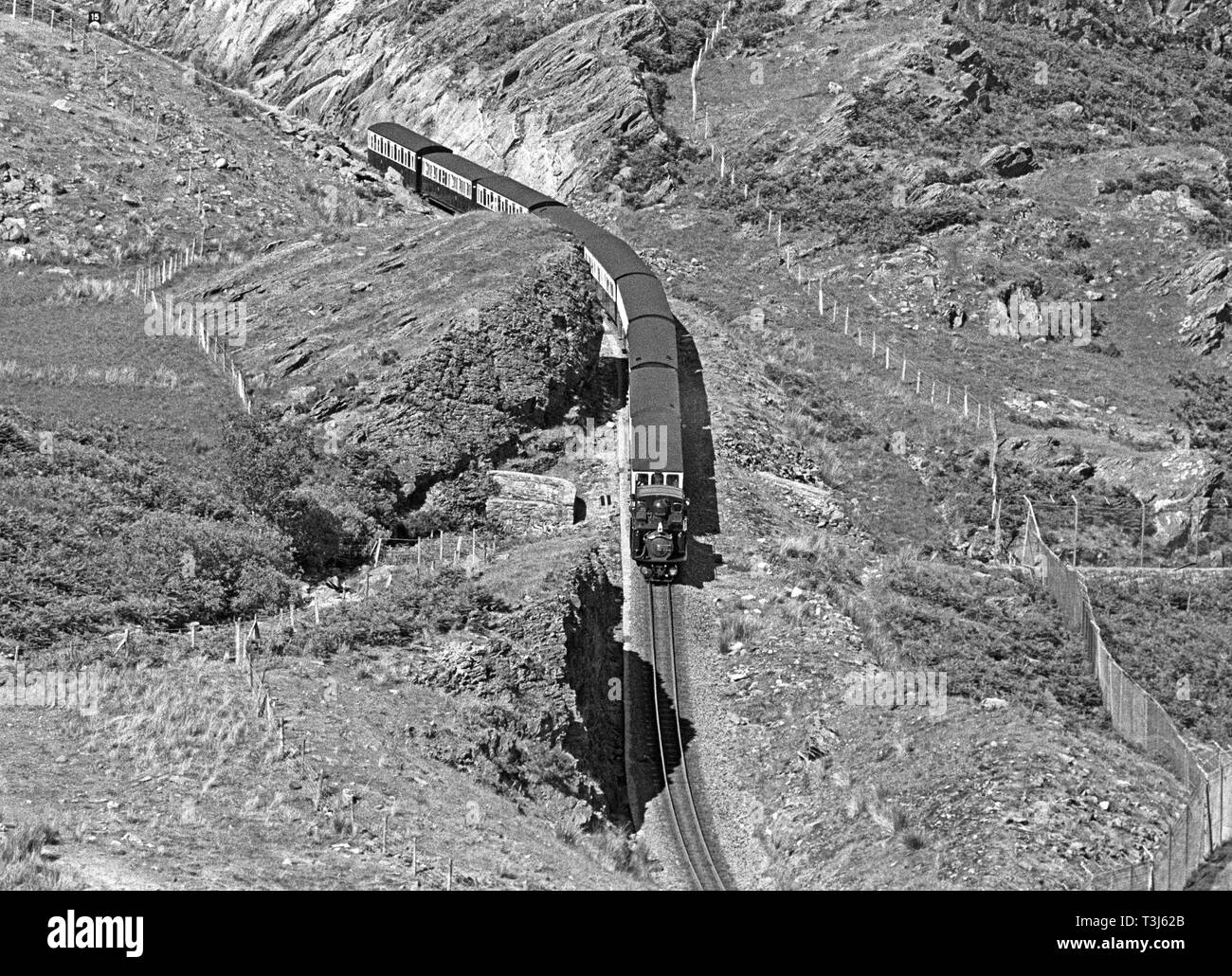Locomotiva a vapore Merddin Emrys sul Ffestiniog Railway in esecuzione attraverso Blaenau Ffestiniog miniere di ardesia, Gwynedd, il Galles del Nord Foto Stock