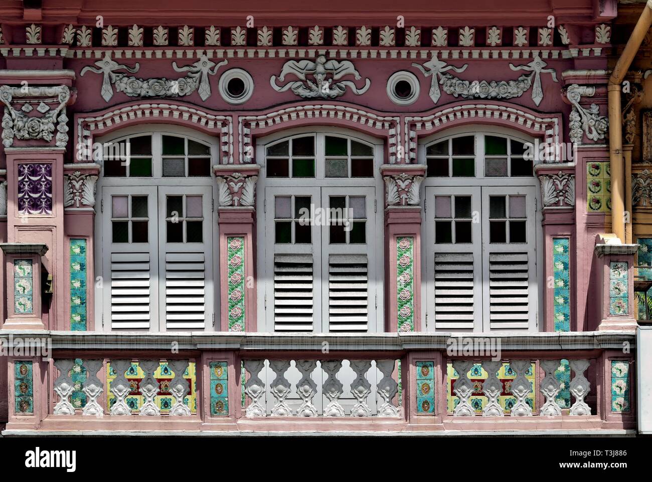 Peranakan di Singapore o Stretto Cinese casa shop esterno con bianco antico persiane di legno e ornato di colonne nella zona del centro storico Foto Stock