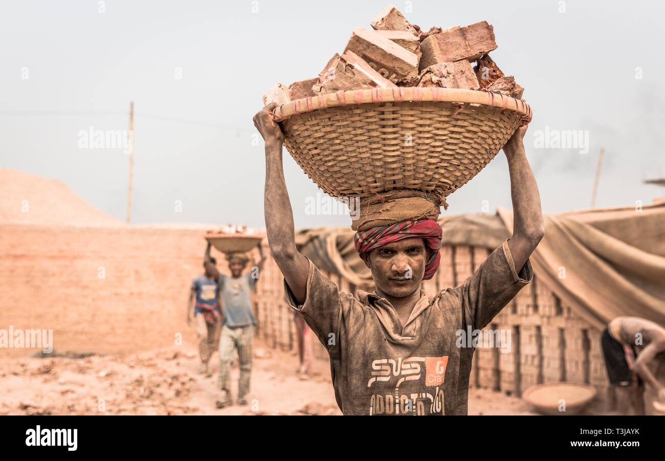 Brickyard lavoratore portare mattoni in un cestello sul suo capo, Dacca in Bangladesh Foto Stock