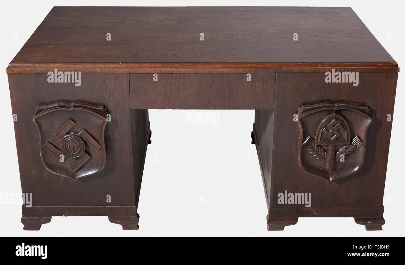 Una scrivania appartenenti a Oberarbeitsführer (Senior leader di lavoro), Wilhelm Krach Arbeitsgau (distretto di lavoro) 24 del medio Reno, Coblenza marrone scuro rovere tinto(?) con due armadi laterali e tre cassetti interni e un cassetto centrale. Quattro cartouches scolpito come stemmi in altorilievo - quelli nel cuscinetto anteriore una testa del grano e una vanga in una corona di grano su una croce uncinata (emblema per RAD - Distinguished Service) o una forcella con una svastica sopra le teste delle spighe di grano (banner emblema). Le due antine in visualizzatore posteriore la Civic stemmi per Krach della precedente posting, Mainz , Editorial-Use-solo Foto Stock