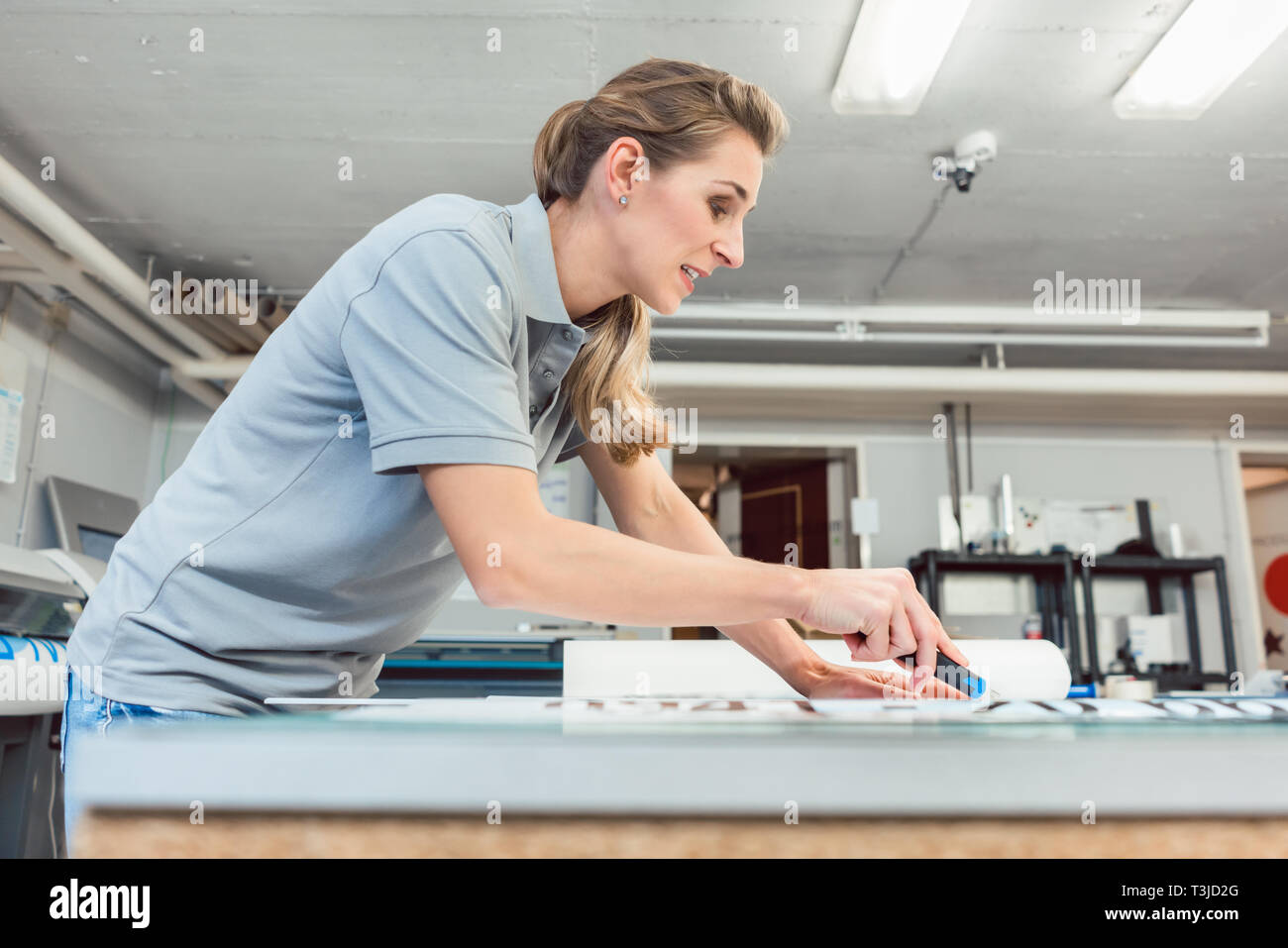 Donna segni di taglio o vinil avvolge la produzione di materiale pubblicitario Foto Stock