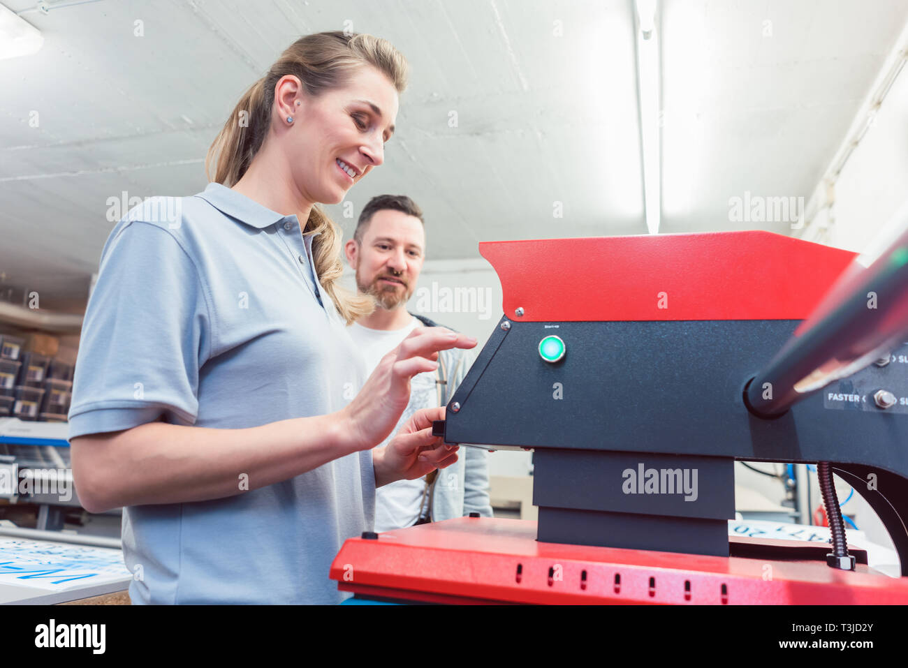 Lavoratori premendo una T-Shirt per effettuare la stampa su di esso ultimo Foto Stock