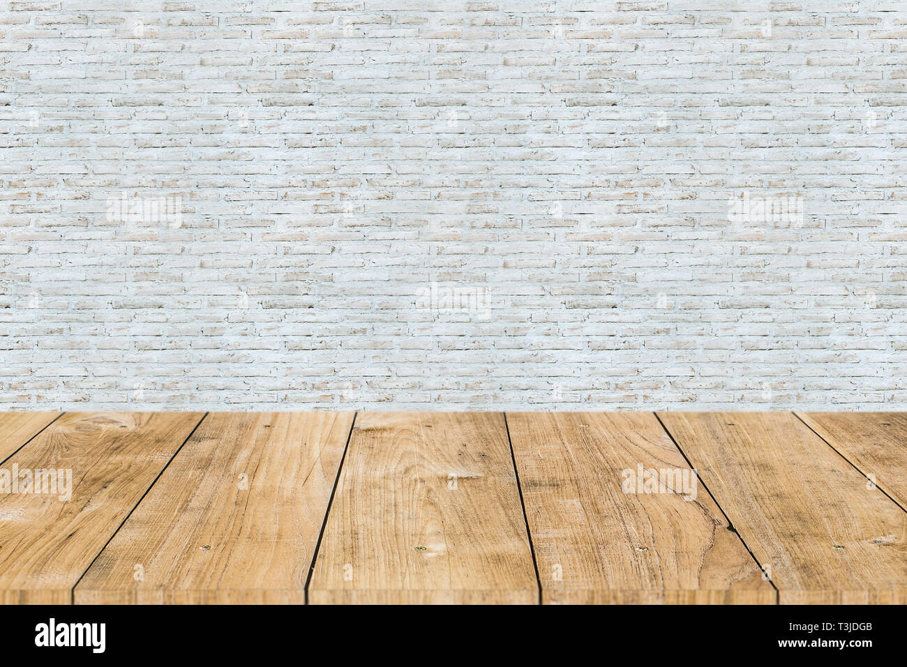 Vernice bianco muro di mattoni con un tavolo di legno primo piano Foto Stock