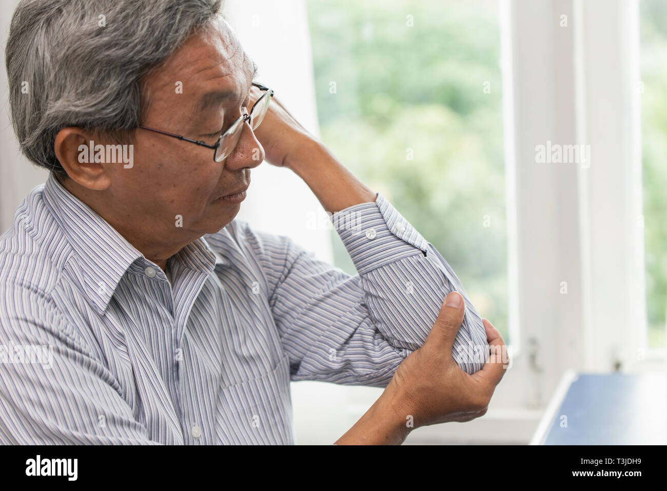 Anziano asiatico soffrono golf dolore a gomito Foto Stock