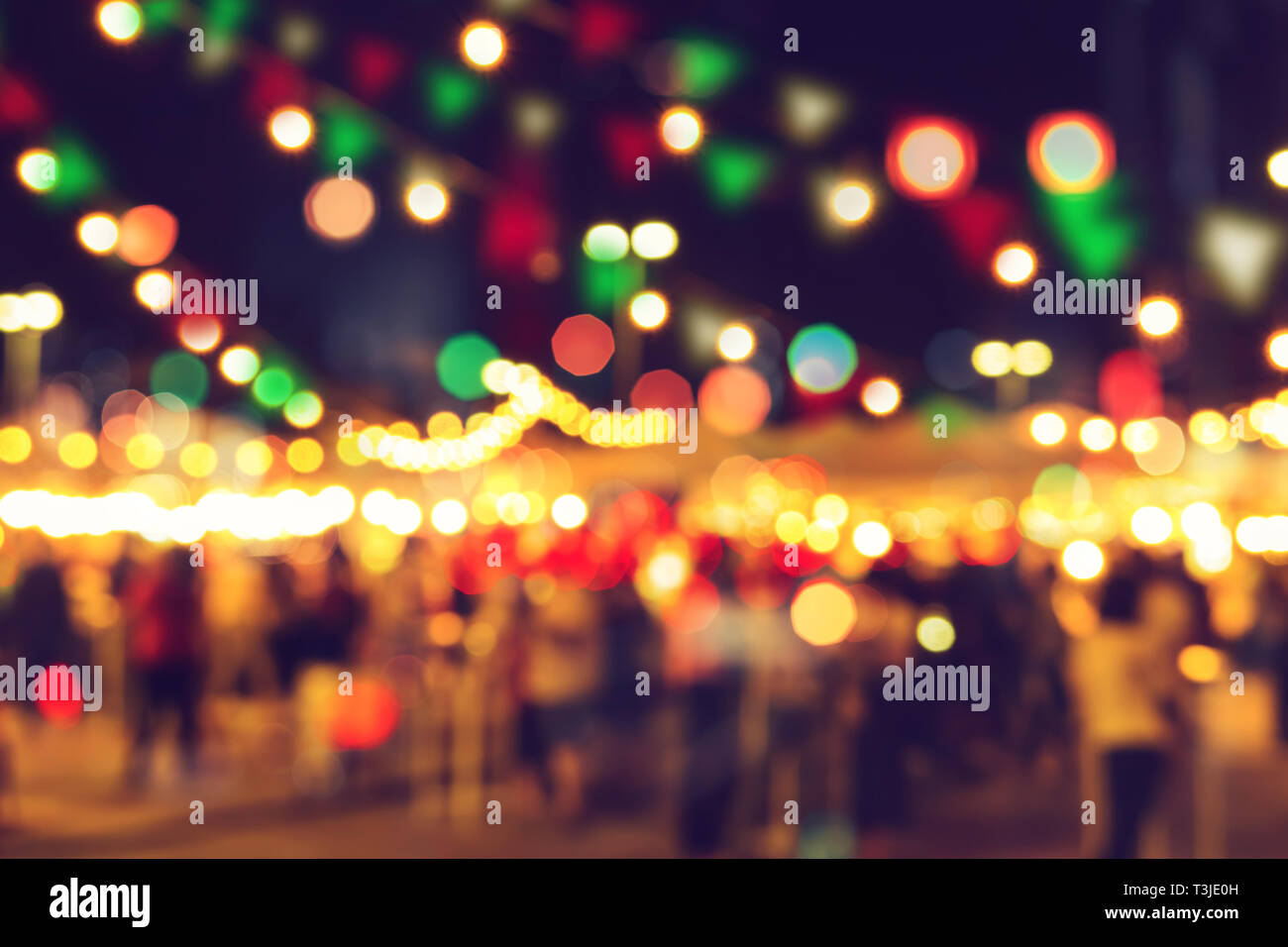 La sfocatura bokeh festival notte calda luce cool chill party in strada a piedi. Foto Stock