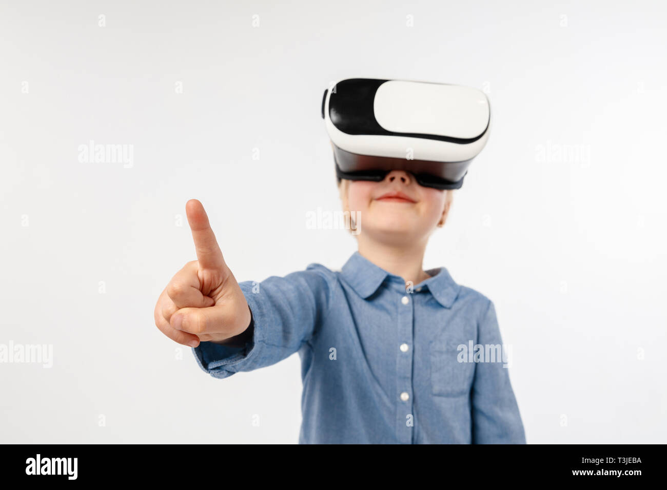Scegli la differenza. Bambina o bambino rivolto verso lo spazio vuoto con occhiali per realtà virtuale isolato su bianco di sfondo per studio. Concetto di tecnologia all'avanguardia, video giochi, l'innovazione. Foto Stock