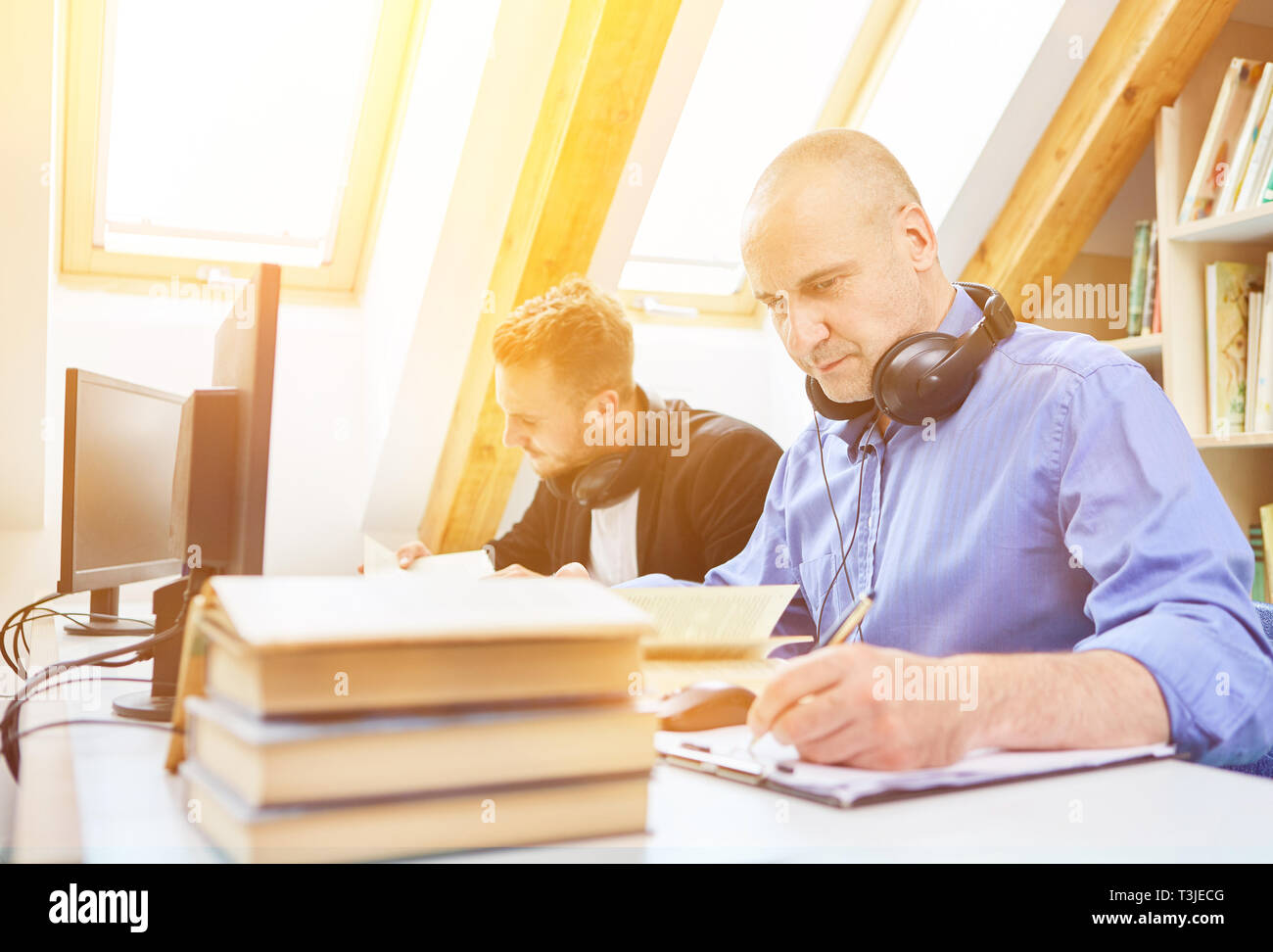 L uomo mentre studiava per esami a un posto di lavoro in una libreria Foto Stock