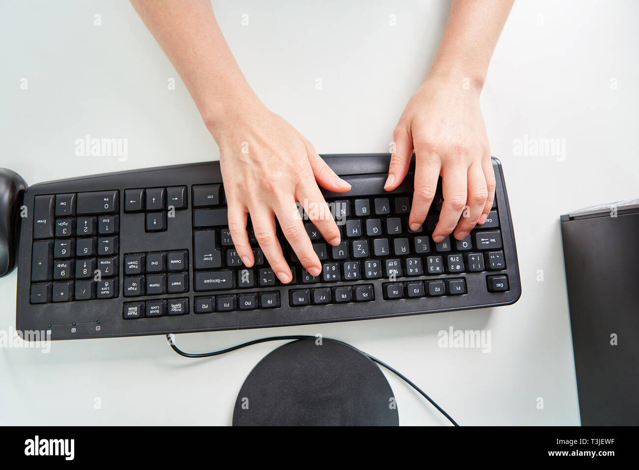 Le mani sulla tastiera di un computer come un simbolo di diligenza e il lavoro di ufficio Foto Stock
