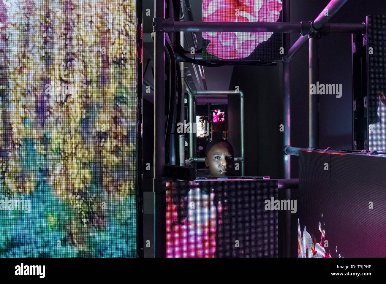 Londra, Regno Unito. Il 10 aprile 2019. Un membro del personale di opere viste in anteprima di una mostra dell'artista tedesco Hito Steyerl presso la Serpentine Sackler Gallery. Attraverso l'uso dell'intelligenza artificiale, la realtà aumentata e le installazioni video, la mostra esamina la potenza e la disuguaglianza nella società, mappatura ineguale distribuzione della ricchezza nelle comunità intorno a Londra la serpentina, che è stata registrata come uno dei più socialmente aree irregolari in Europa. Credito: Stephen Chung / Alamy Live News Foto Stock