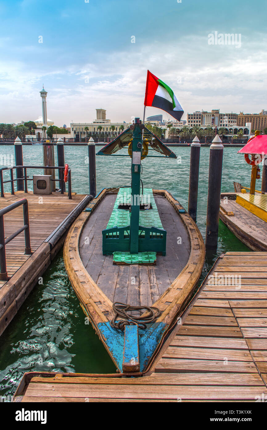 Tradizionale giro in barca Abra Dubai Deira Creek, luogo da visitare in Dubai lago blu con battenti bandiera degli EMIRATI ARABI UNITI Foto Stock