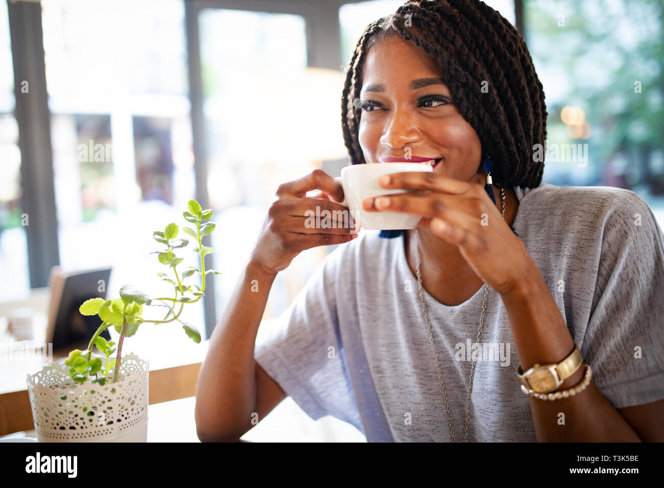 Bella giovane donna africana gustando una tazza di caffè Foto Stock