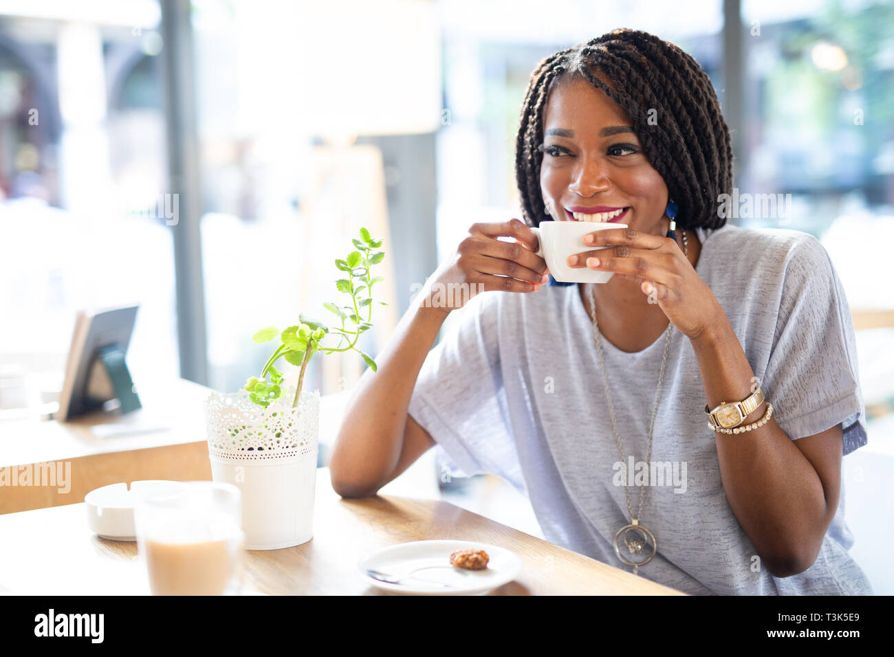 Bella giovane donna africana gustando una tazza di caffè Foto Stock