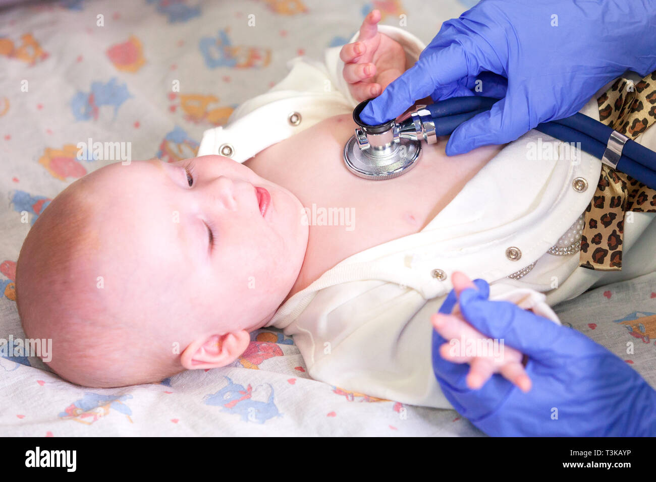 Carino piccolo bimbo e il dottore le mani con uno stetoscopio Foto Stock