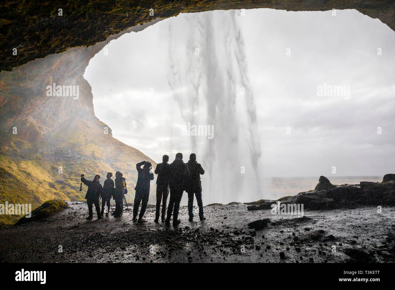 Seljalandsfoss cascata, turisti sta immagine sotto la cascata Foto Stock