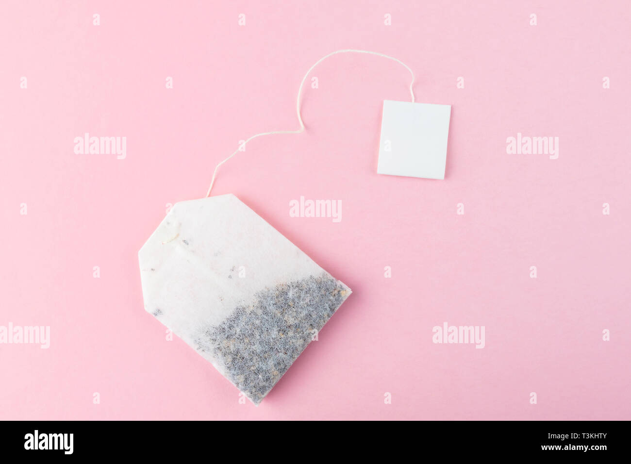 Bustine di tè con etichette bianche su sfondo di colore rosa pastello superficie. Vi è uno spazio vuoto per il testo o il logo Foto Stock