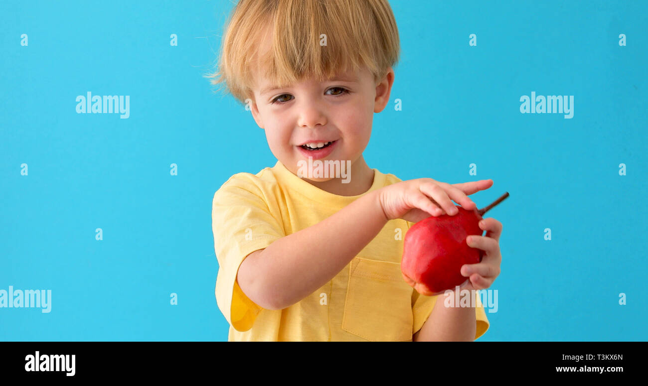 Sweet Little Boy sorrisi con red pera Foto Stock