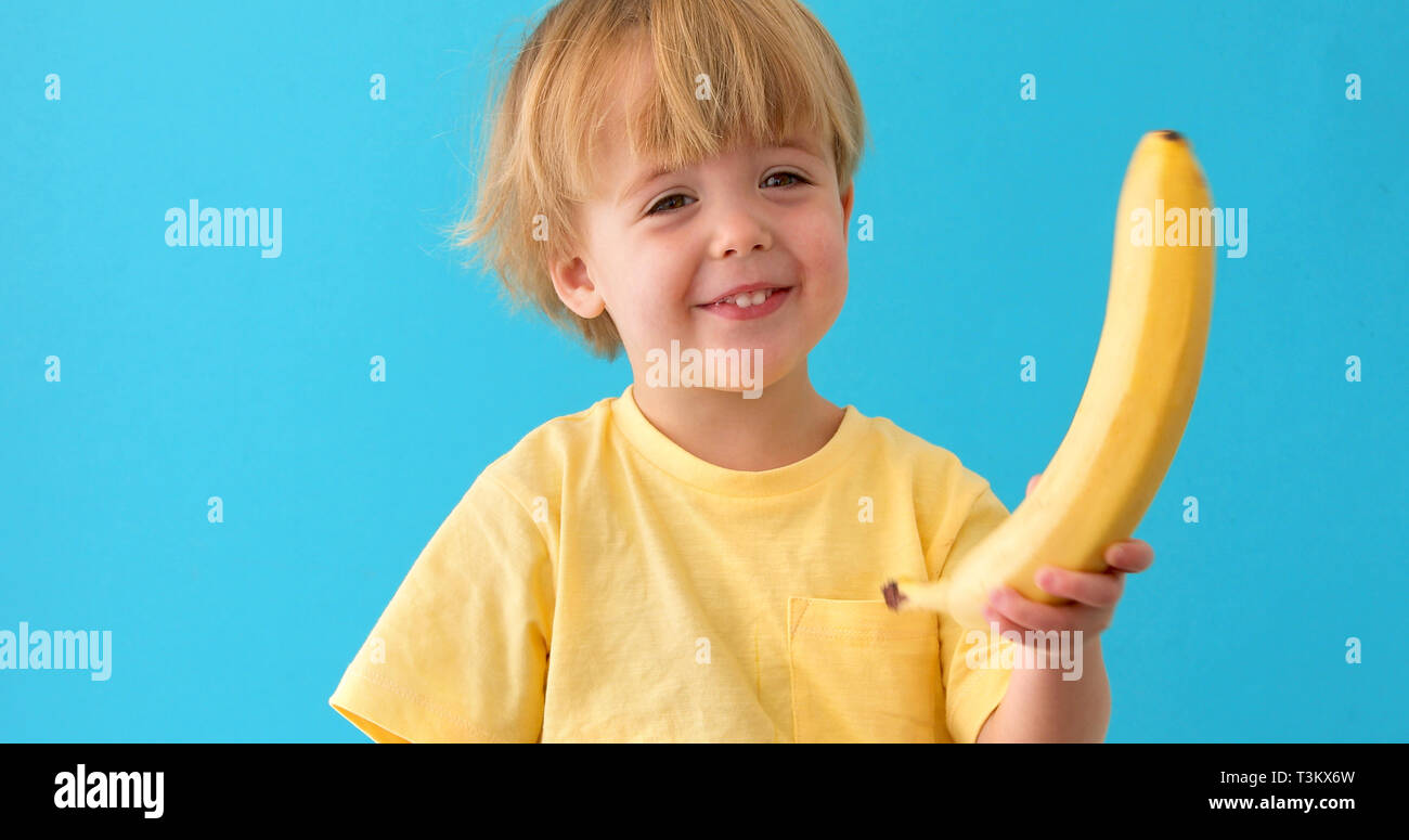 Divertente ritratto di carino piccolo ragazzo con banana Foto Stock