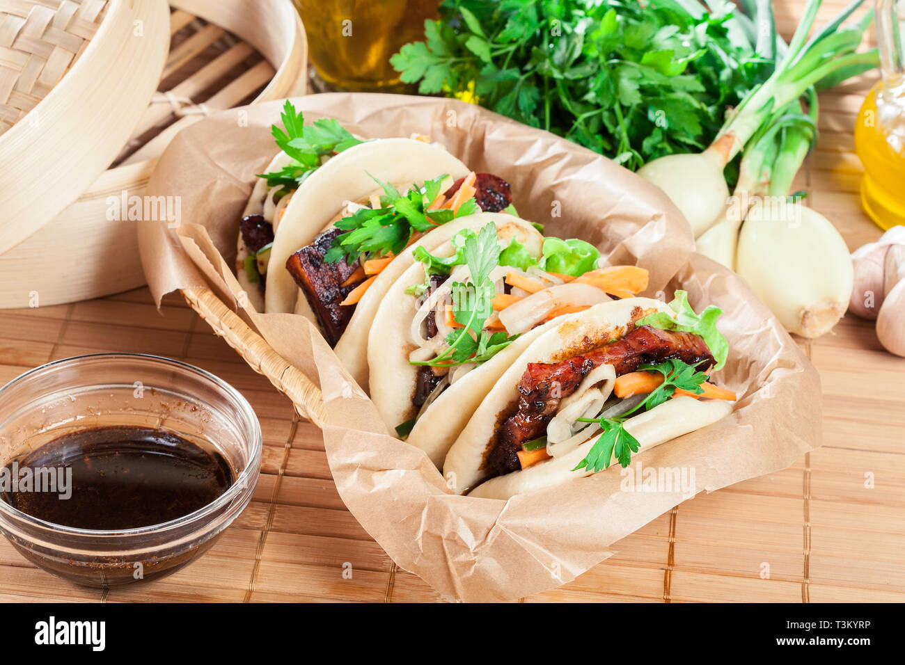 Gua bao, focacce cotte al vapore con pancetta di maiale e verdure. Cucina asiatica Foto Stock