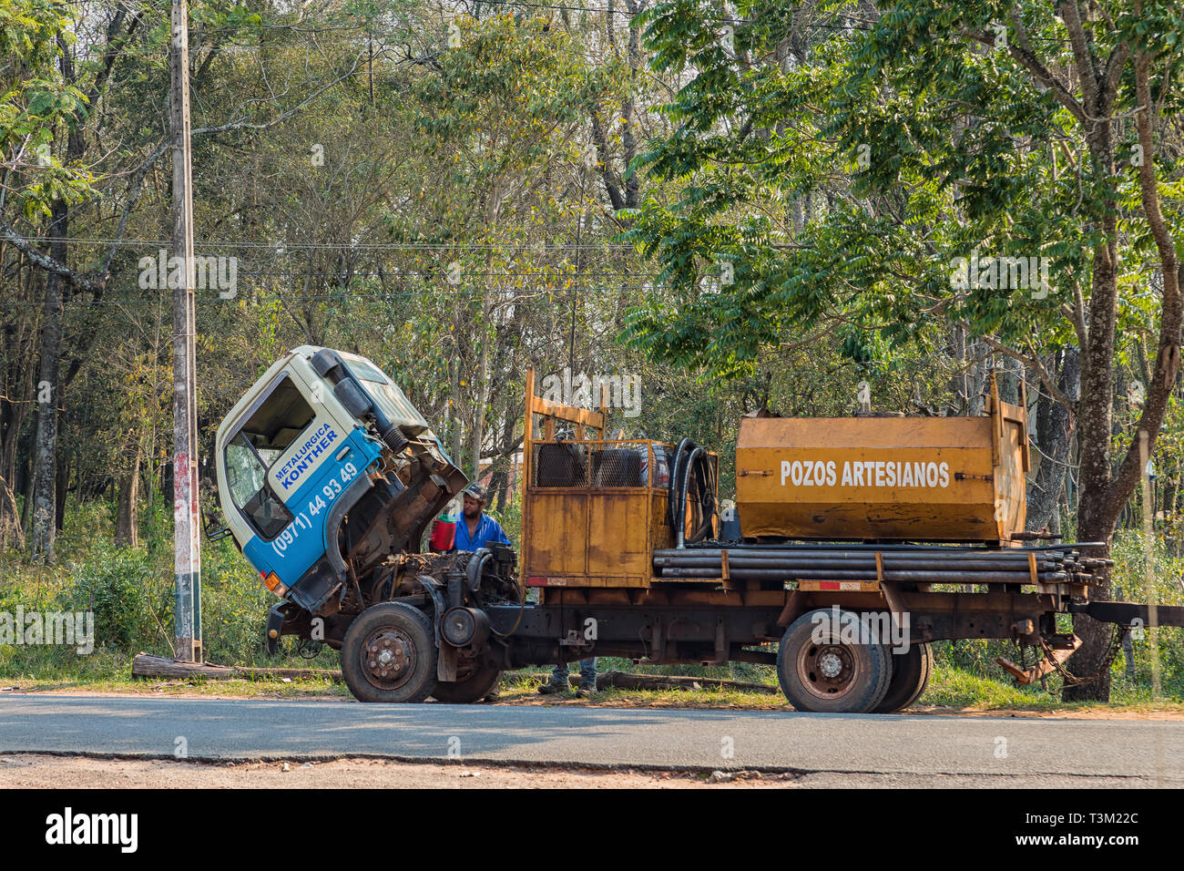 Colonia Independencia, Paraguay - Agosto 30, 2018: carrello guasto su una autostrada in Paraguay. Conducente rifornisce di acqua di raffreddamento. Foto Stock