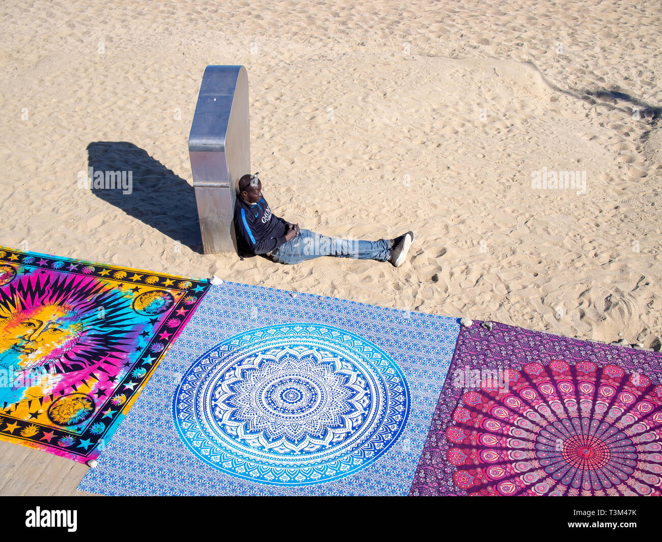 Barcellona, Spagna-marzo 18, 2019: rifugiati africani venditore di tappeti sulla spiaggia di Barceloneta Foto Stock