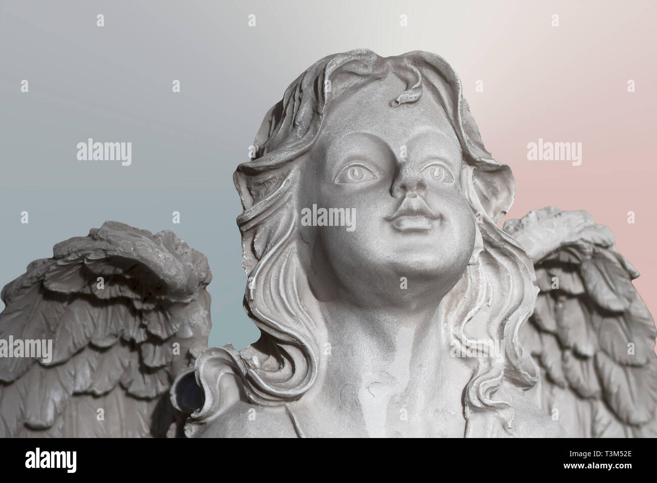 Statua di pietra bianca pregando angelo su backgrouond pastello, il viso e le ali di close-up. Messa a fuoco selettiva Foto Stock