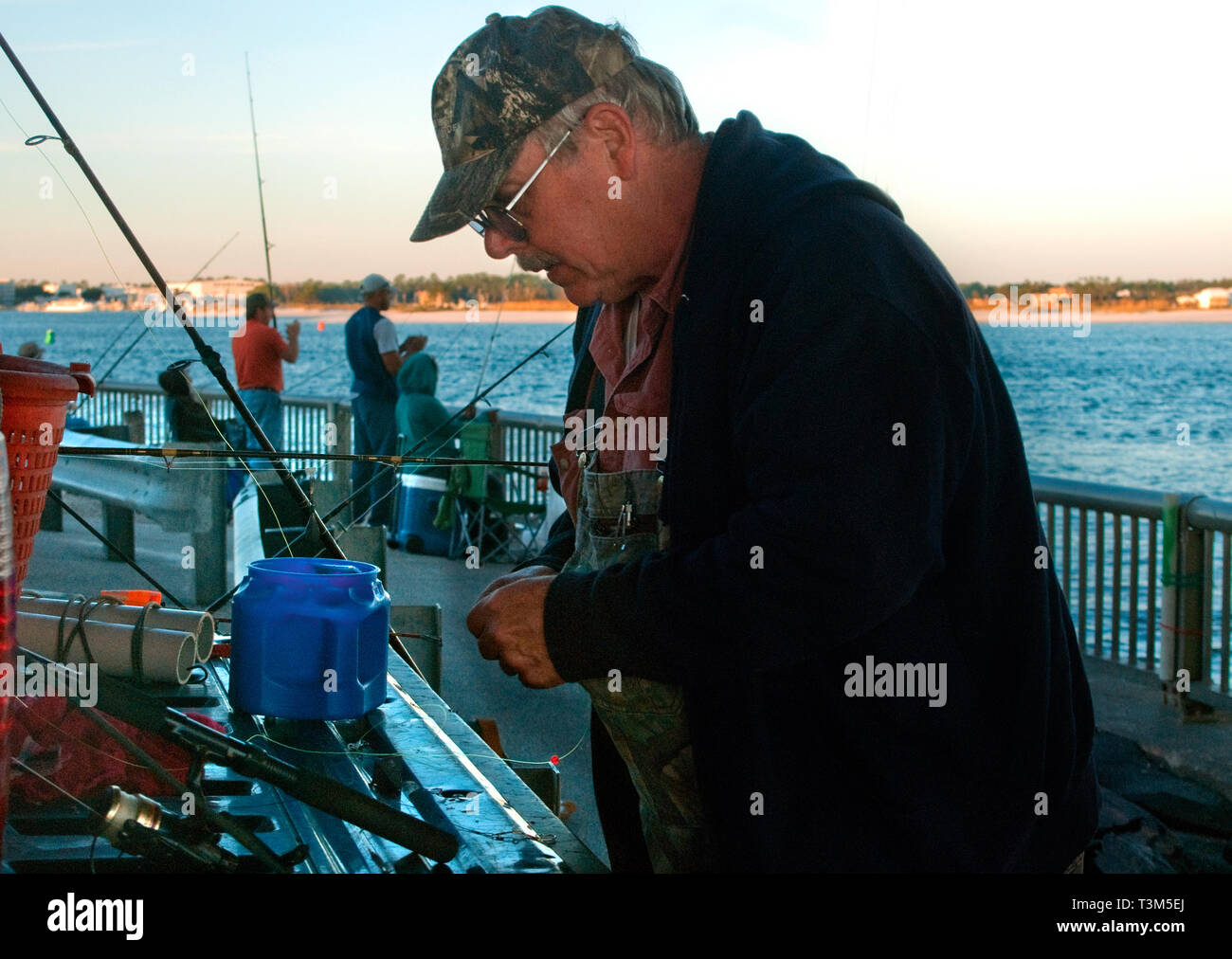 Un uomo lavora sulla sua linea di pesca a Florida punto, nov. 12, 2009, in Orange Beach, Alabama. Foto Stock