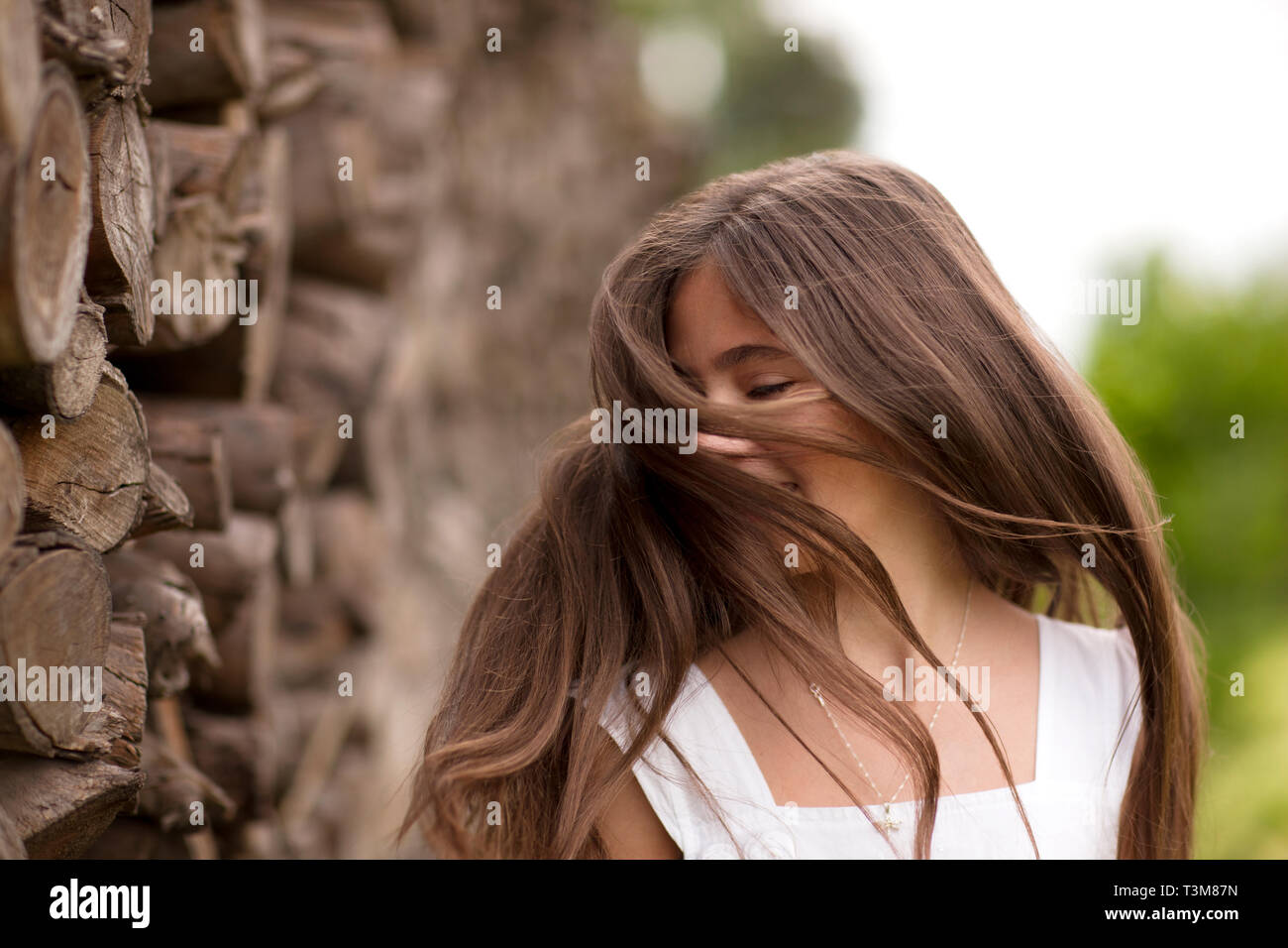 Ragazze Preteen flicks i suoi capelli come essa si erge accanto ad una parete di roccia. Foto Stock