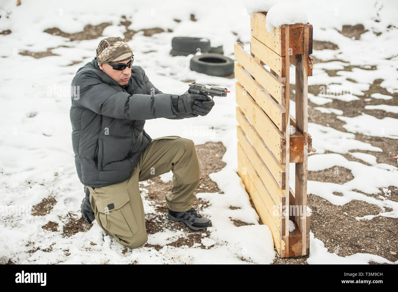 Pistola di combattimento addestramento al tiro da dietro e intorno al coperchio o barricade. Advanced combattimenti tattici corsi di tiro sul poligono di tiro Foto Stock