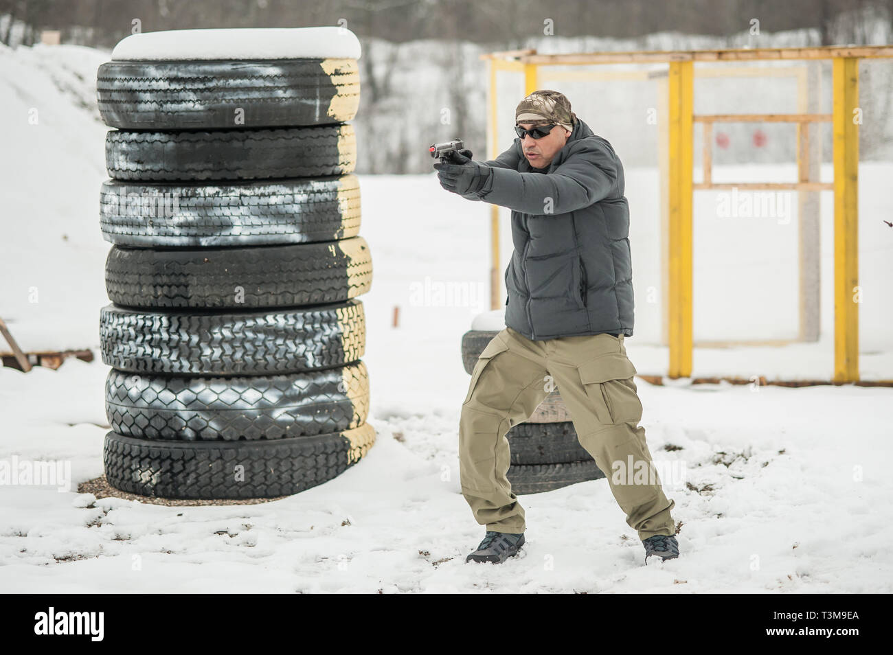 Pistola di combattimento addestramento al tiro da dietro e intorno al coperchio o barricade. Advanced combattimenti tattici corsi di tiro sul poligono di tiro Foto Stock