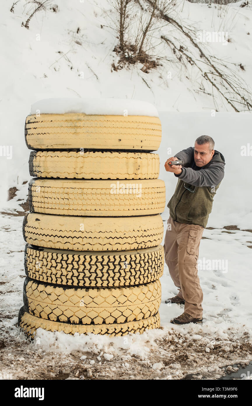 Pistola di combattimento addestramento al tiro da dietro e intorno al coperchio o barricade. Advanced combattimenti tattici corsi di tiro sul poligono di tiro Foto Stock