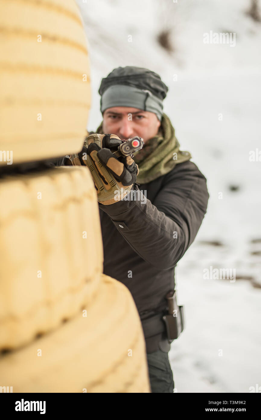 Pistola di combattimento addestramento al tiro da dietro e intorno al coperchio o barricade. Advanced combattimenti tattici corsi di tiro sul poligono di tiro Foto Stock
