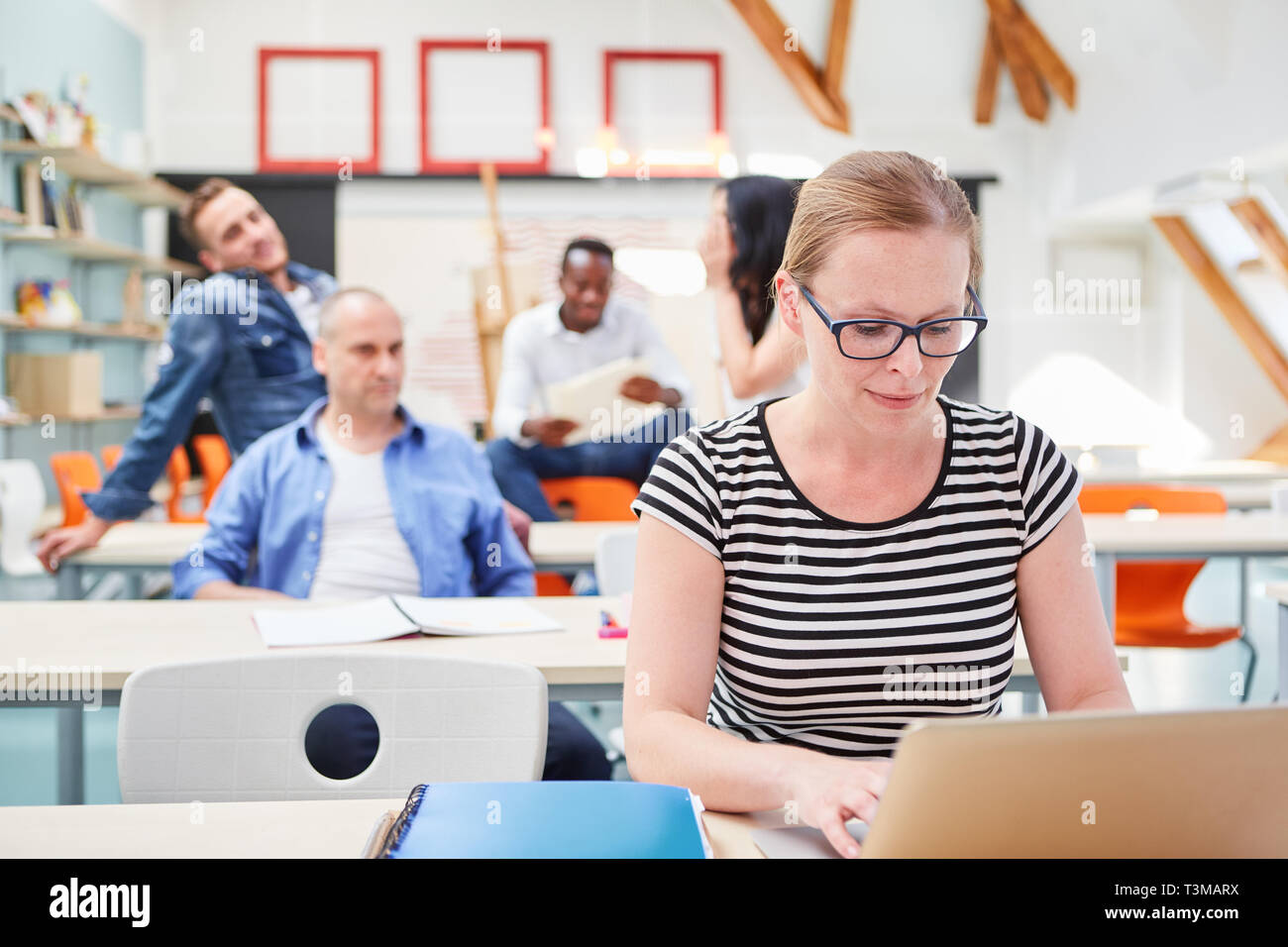 La donna come uno studente in un seminario per ulteriore istruzione funziona su computer portatile Foto Stock