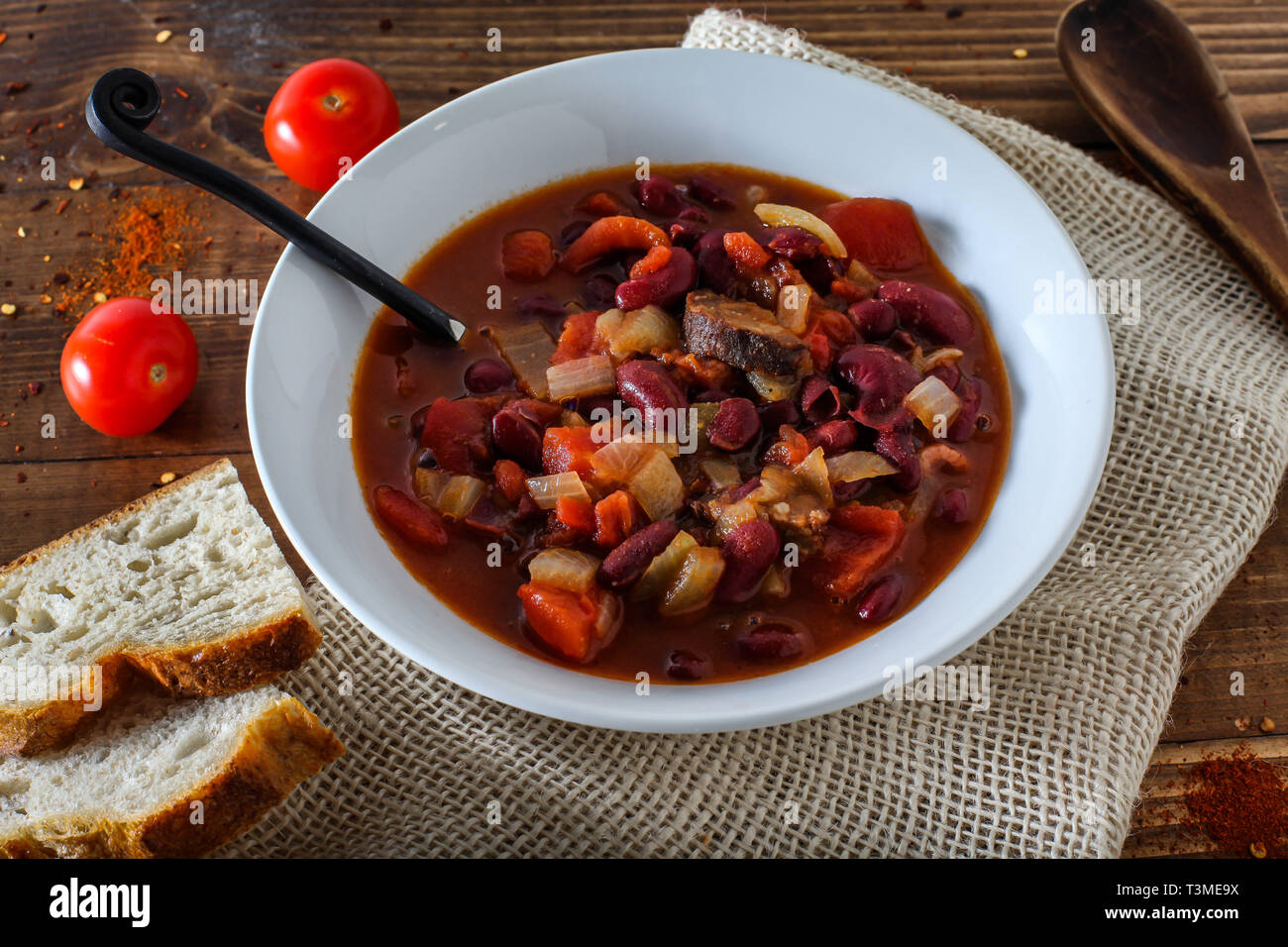 Paese uomo stufato di fagioli rossi, i pomodori e le salsicce Foto Stock