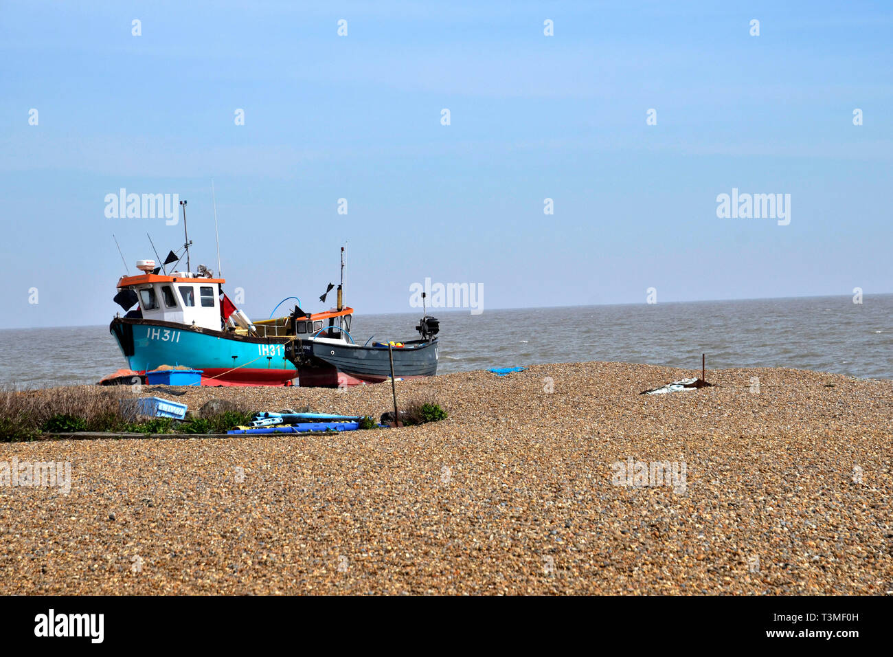 Barche da pesca sulla bandiera blu spiaggia di ciottoli nel Suffolk Coastal Town di Aldeburgh Foto Stock