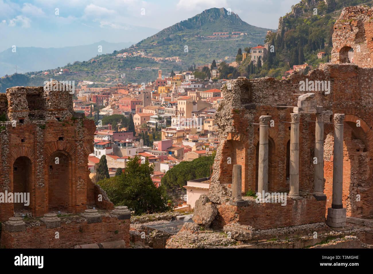 Le rovine del teatro greco antico e la città vecchia di Taormina in giornata di sole, Sicilia, Italia Foto Stock