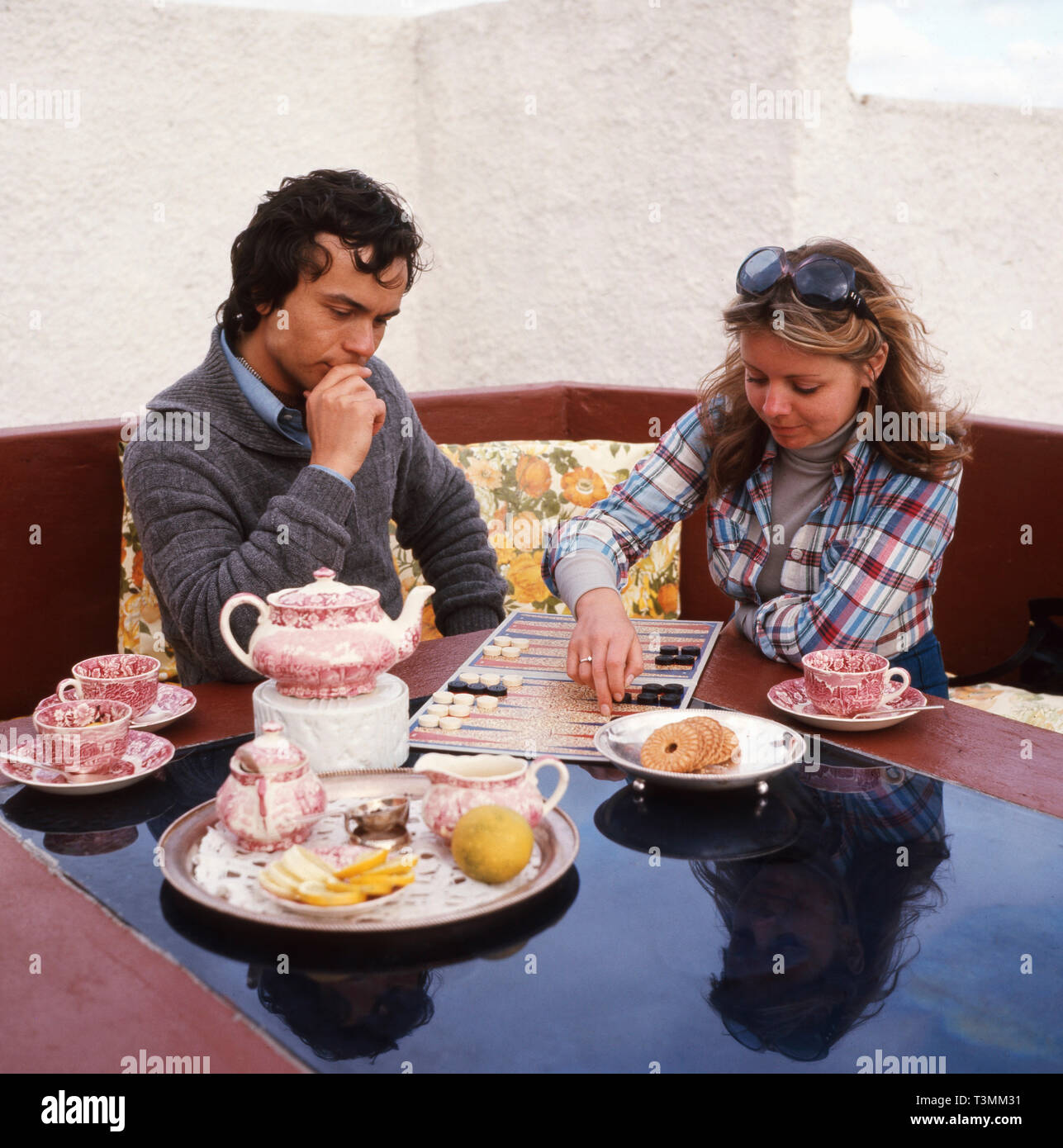 Deutscher Komponist, Sänger und Gitarrist Hennerici Hoier mit einer Freundin beim spielen Backgammon Sommerurlaub im, ca. 1980er. Compositore tedesco, cantante e chitarrista Hennerici Hoier giocando con una ragazza di backgammon in vacanza estiva, ca. Degli anni Ottanta. Foto Stock