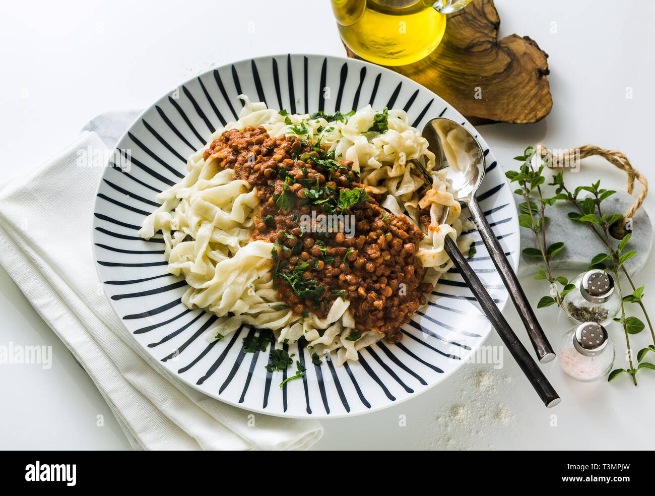 Vegan pasta con le lenticchie e salsa di pomodoro in un piatto sul tavolo. cibo sano Foto Stock