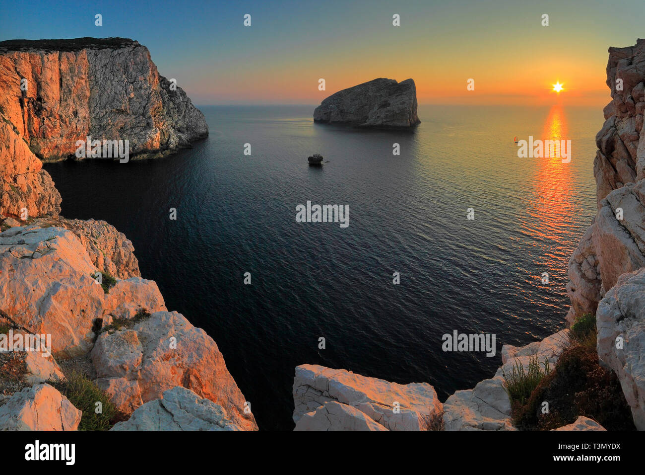 Una vista al tramonto degli enormi pareti verticali di calcare di falesie di Capo Caccia, uno splendido promontorio sulla costa occidentale della Sardegna in Ital Foto Stock