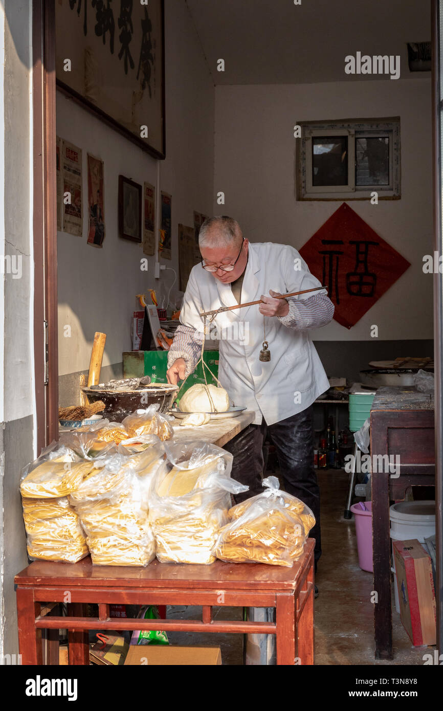 Anziani cinese di preparare la pasta per le tagliatelle, Jinan, provincia di Shandong, Cina Foto Stock