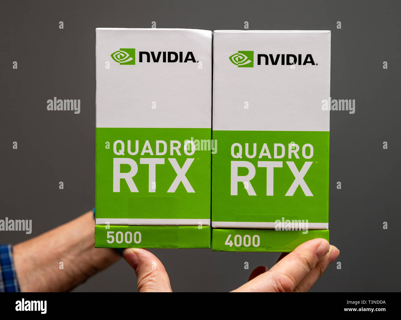 Parigi Francia - Mar 28 2019: Senior uomo che mostra le scatole di cartone vista laterale unboxing di Nvidia Quadro 4000 RTX 5000 GPU per workstation dotate di nuovi multiprocessori streaming anime del tensore di sfondo grigio Foto Stock