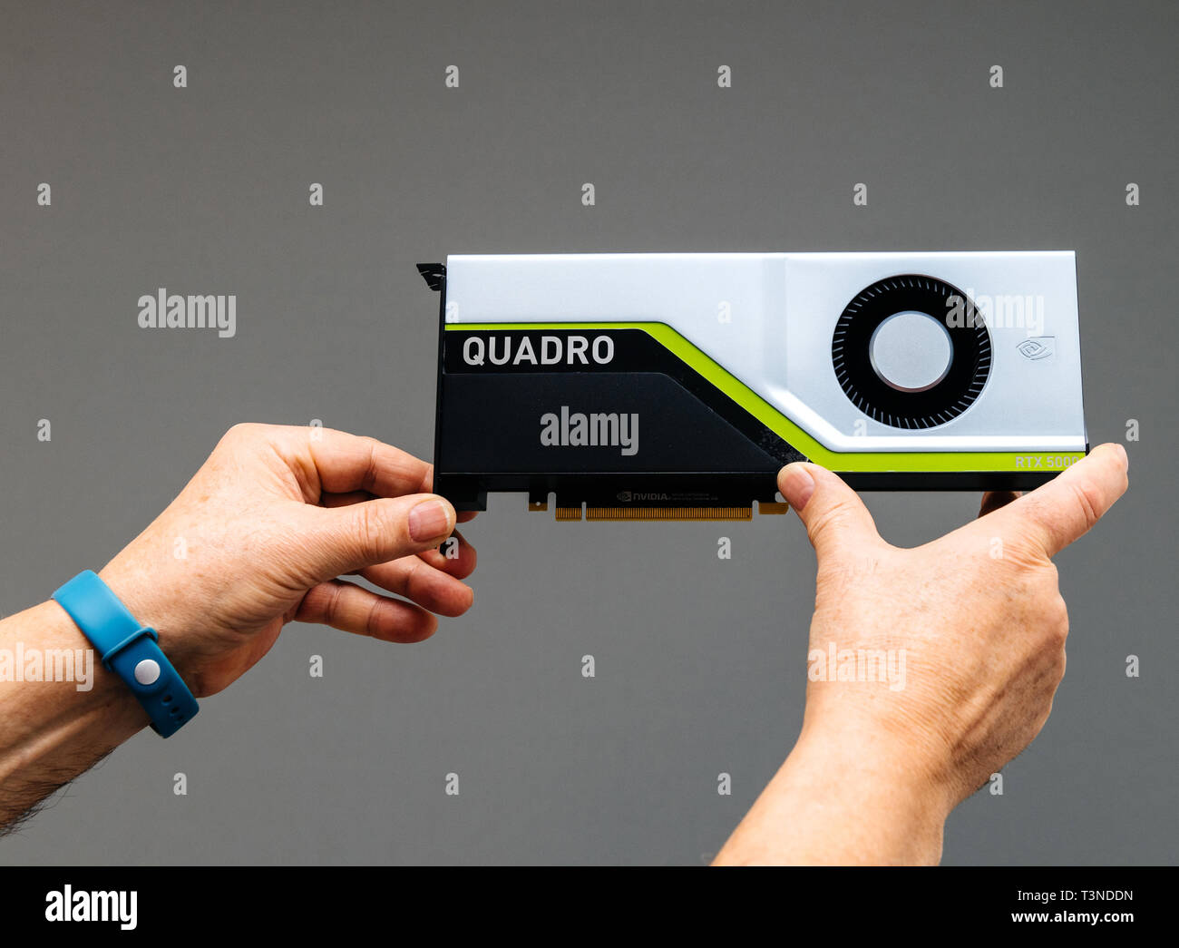 Parigi, Francia - Mar 28 2019: Senior uomo mostra ultima Nvidia Quadro RTX workstation 5000 GPU con texture mapping di unità, rendere le unità di uscita, streaming multiprocessori, anime del tensore di sfondo grigio Foto Stock