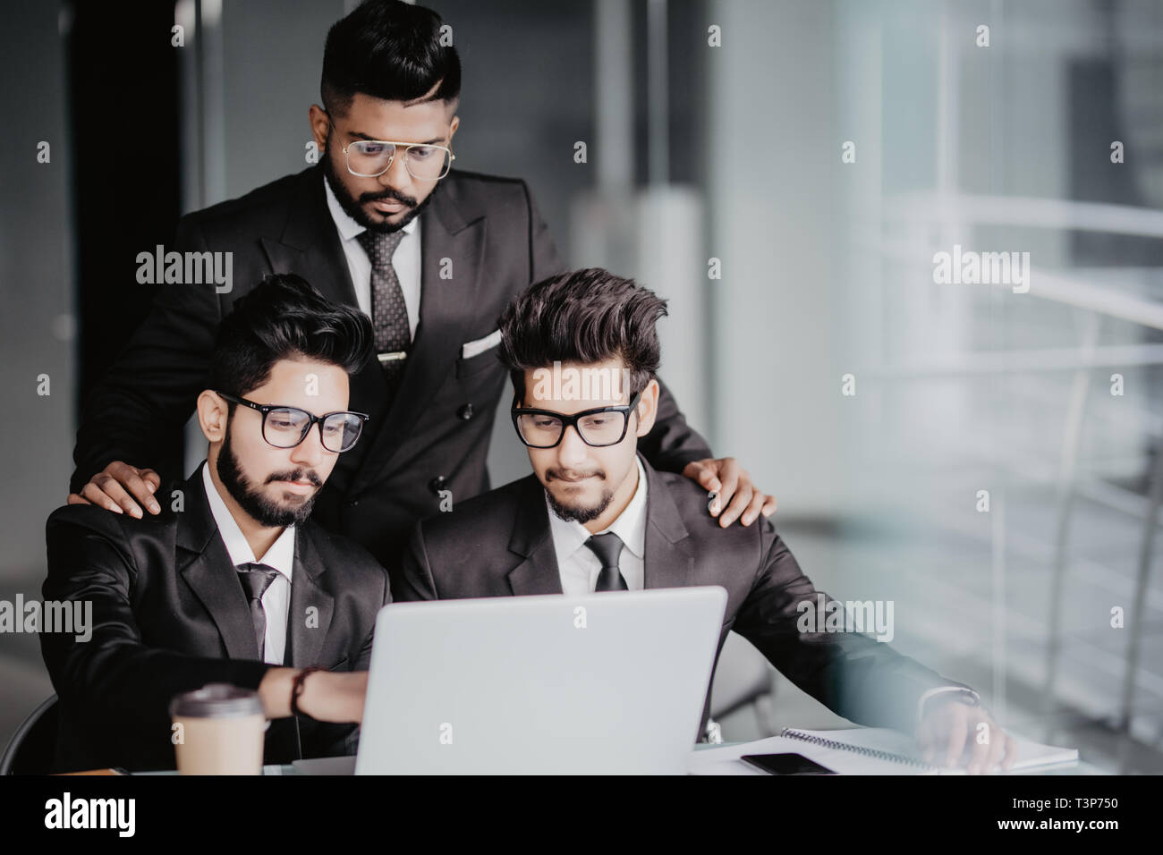 Ritratto di tre collaboratori a discutere di business plan in ufficio Foto Stock
