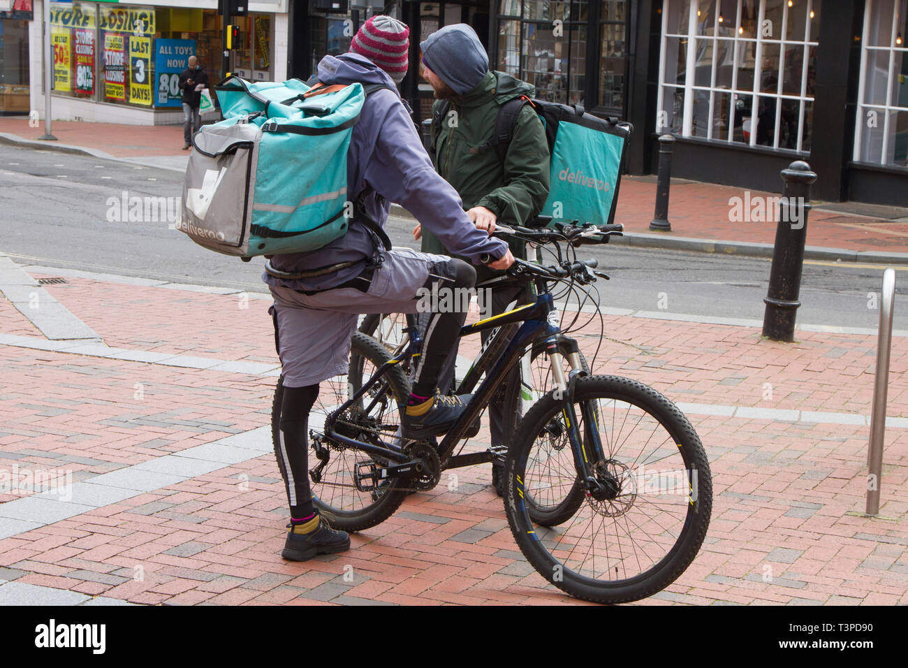 Due Deliveroo bicicletta piloti di consegna nel centro di Reading Foto Stock