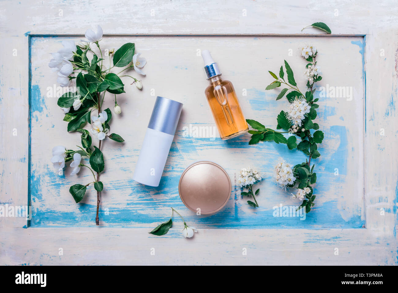 Organici naturali cosmetici: siero, crema, maschera sullo sfondo di legno con fiori. Dermocosmesi concept Foto Stock
