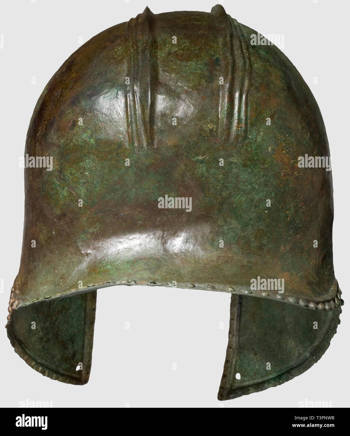 Un casco illiriche, VI secolo A.C. Bronzo con patina verdastra. Cranio di forma sferica con una triplice sagomato base di cresta, un gancio per fissare la cresta sul forehaed. Faccia rettangolare intaglio, la guancia appuntita pezzi con la perforazione per la cinghia per il mento. Leggermente curvo collo-guard. Due inseguito linee decorative sopra la faccia intaglio, il perimetro circondato da una cornice in rilievo e una linea di rivetti decorativi. Altezza 22 cm. Leggermente distorto il casco con alcuni piccoli restauri, collo-guard sostituito completamente, storico, storico mondo antico, Additional-Rights-Clearance-Info-Not-Available Foto Stock