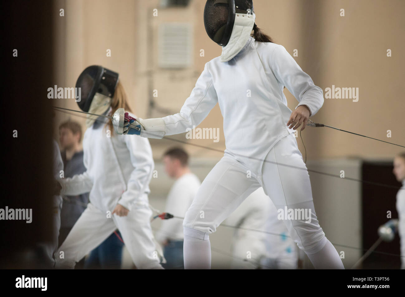 I giovani schermitori in piedi la sala su un torneo di scherma e tenetevi pronti per la lotta Foto Stock